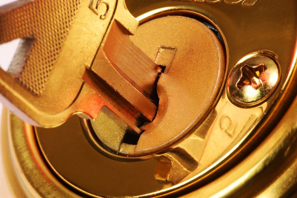 ANC Locksmiths residential and commercial. Gold key inside a gold lock.